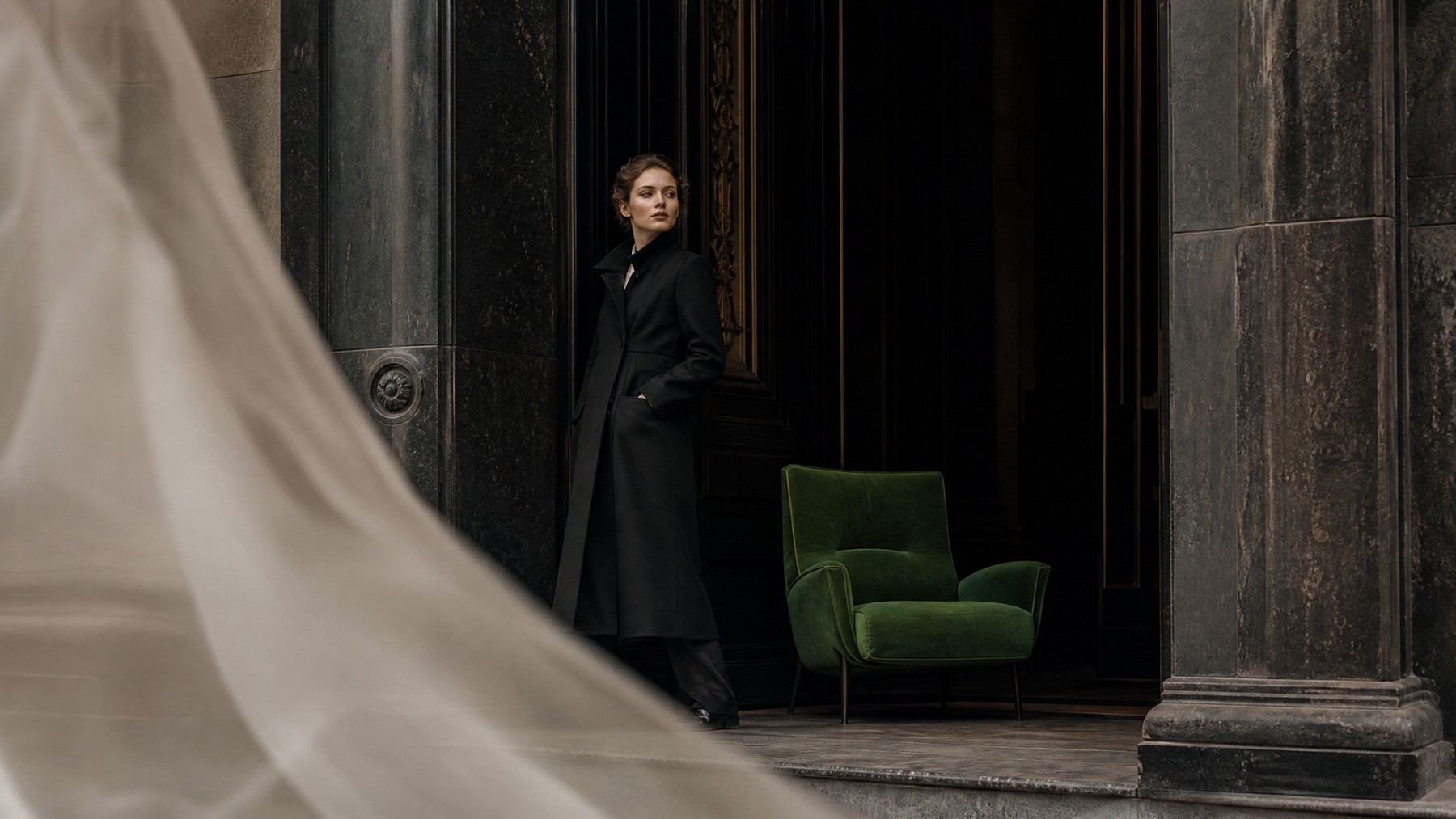 An elegantly dressed woman waits in a dark doorway beside an empty green chair, suggesting the welcome a website must create for unfamiliar visitors.